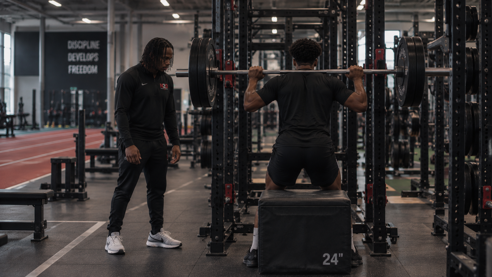 Ngila coaching an athlete during a Strength and Conditioning box squat session